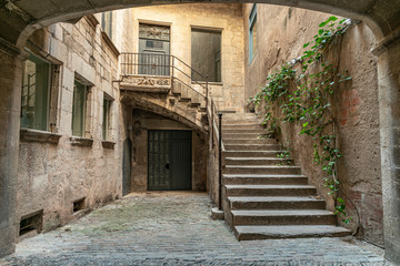 Fototapeta na wymiar Entrance to an old house in Girona. Stairway to a still used medieval home in Northern Catalonia
