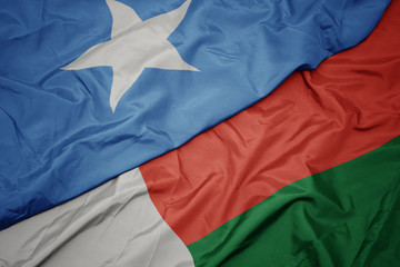 waving colorful flag of madagascar and national flag of somalia.