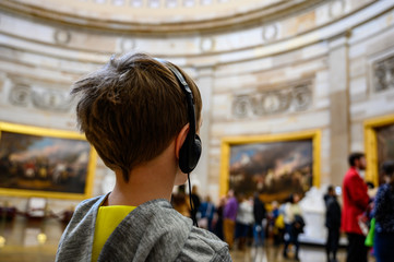 Young Caucasian boy with headset on tour of US Capital in Washington DC