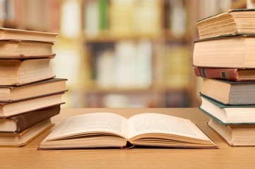 Stack of old books on bokeh library background