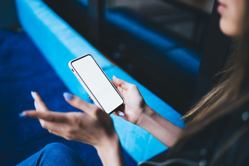 Faceless young woman using smartphone