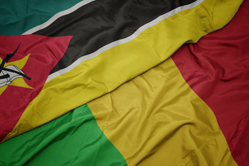 waving colorful flag of mali and national flag of mozambique.