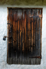 Close up old wooden door with rusty hinges