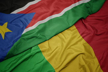 waving colorful flag of mali and national flag of south sudan.