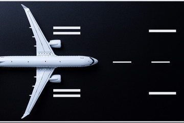 Airplane on black runway. Top view on aircraft. Concept of business travel and aerospace indusrty