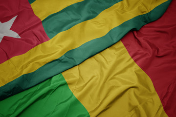 waving colorful flag of mali and national flag of togo.