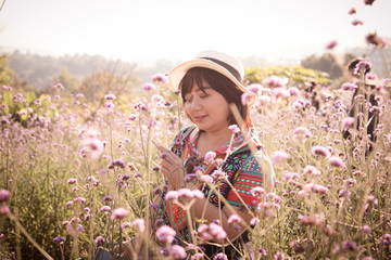 outdoor portrait of a beautiful middle aged Asian woman happiness in the flower field.