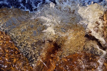 water stream cascade falling on the rocks close up