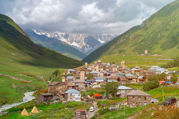 Fototapeta premium View of the Ushguli village at the foot of Mt. Shkhara. Picturesque and gorgeous scene. Rock towers and old houses in Ushguli, Georgia.