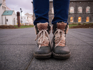 Cosy girl leather boots on the ground, in the Austurvöllur public square. Reykjavik, Iceland.