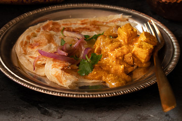 Indian cottage cheese with flat breads served in copper bowl
