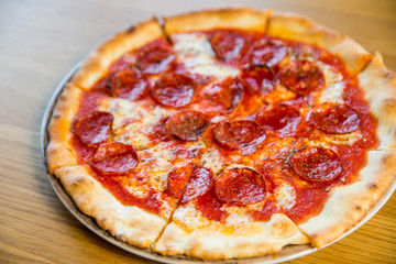 round pizza with sausage, cheese and spices