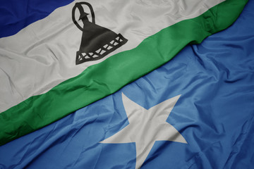 waving colorful flag of somalia and national flag of lesotho.
