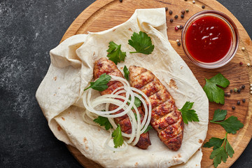 Lula kebab with pita bread on a wooden board