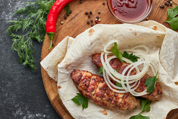 Lula kebab with pita bread on a wooden board