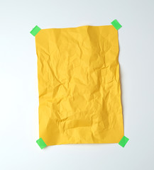 empty yellow crumpled sheet of paper glued with green sticky pieces of paper