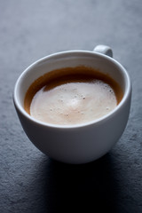 Cup of coffee on dark stone background. Close up. 