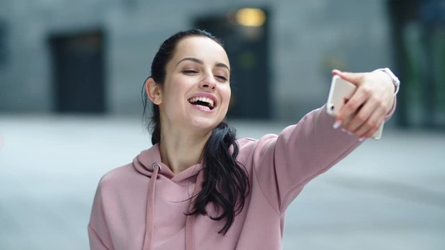 Closeup cheerful woman posing for selfie photo. Happy woman showing victory sign