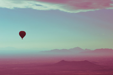 Hot Air Balloon floating over the Misty Mountains of the Arizona Desert near Phoenix