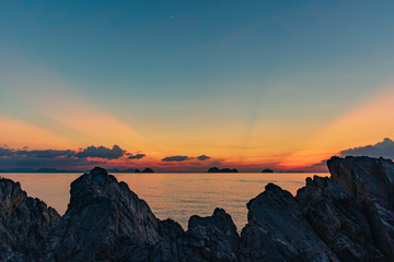 Fototapeta na wymiar Spectacular sunset over rocks on the beach 