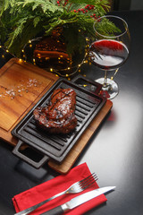 Steak on a wooden board. Restaurant serving with red wine.