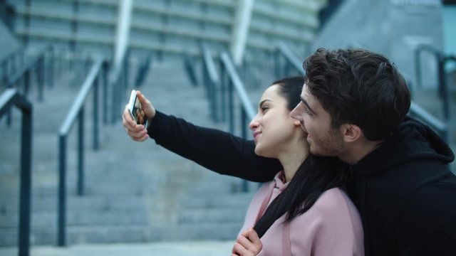 Fitness couple taking selfie photo to smartphone. Funny couple posing for selfie