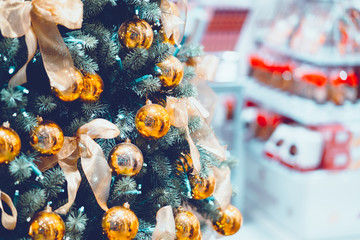 Christmas trees with golden ball decoration in shopping mall. Blurred background