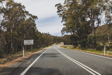 Fototapeta premium Australian countryside road trip view from the car with empty road and eucalyptus bush,
