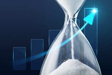 Sand running through the bulbs of an hourglass on business chart background