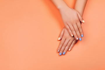Obraz na płótnie Canvas Manicure in trendy colors: coral, rose gold and blue on colorful background. Flat lay style.