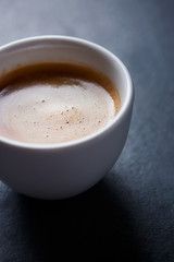 Cup of coffee on dark stone background. Close up. 