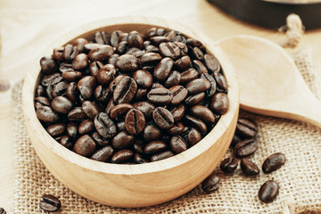 Coffee bean on wooden bowl with home made coffee background