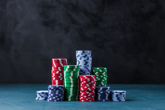 stack of poker chips on a blue table on a black background