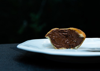 chocolate pie on white plate, chocolate pie on black background, chocolate pie