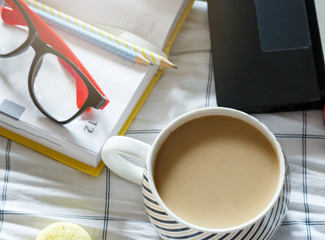 Close up of  pencils,  notebook and cup of coffee in the bed. Workspace for freelance. Deadline time concept. Flat lay 