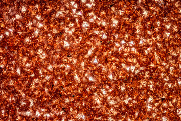 Exteme macro of a Goldstone polished surface (2.2mm width). Goldstone is a type of glittering glass made in a low-oxygen reducing atmosphere. Another common name for the material is Aventurine glass