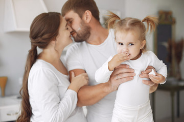Cute little daughter in a white sweater. Family at home in a kitchen. pregnant woman.