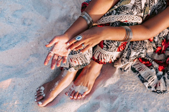 close up of stylish young woman with boho accessories on the beach at sunset