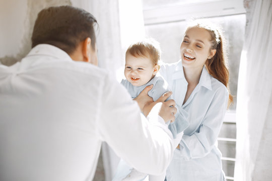 Cute family in a room. Lady in a white shirt. Little girl with parents