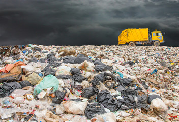garbage dump pile in trash dump or landfill,truck is dumping the gabage from municipal,garbage dump whit old garbage truck and dark clouds or rain clouds
