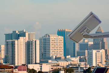 Fototapeta premium CCTV closed circuit camera in landscape of city with lots of buildings on the background