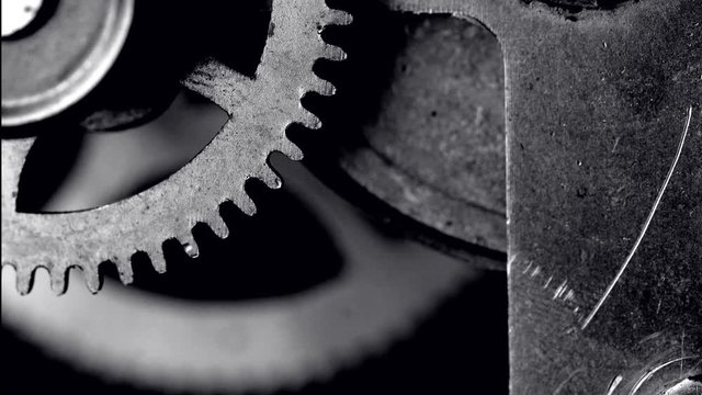Time lapse footage of antique clock gears in motion (black and white)