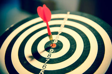 Red dart arrow hitting in the center of bullseye for Business focus concept.