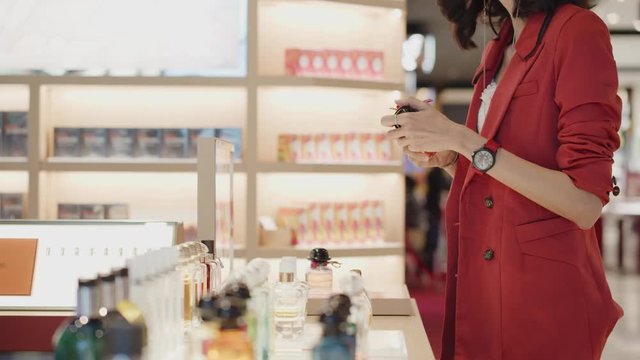 Woman talks with the perfumer at a department store as she shiff, smells, tests a new fragrance