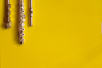 Top view flute traverse over yellow background. music concept. flutist player.