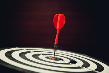 Red dart arrow hitting in the center of bullseye for Business focus concept.
