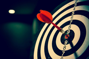 Red dart arrow hitting in the center of bullseye for Business focus concept.