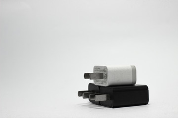 Black and white USB wall charger plug with white background.