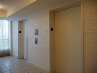 Hallway facing a couple of elevators in a building