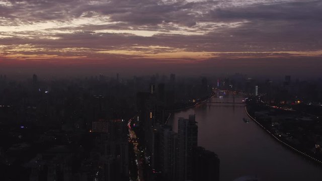 Beautiful aerial view on Guangzhou endless suburb districts and pearl river during epic red sunset with clouds, China, Guangdong.